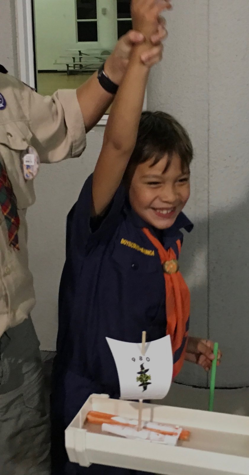 Jack as a Cub Scout celebrating with a handmade boat